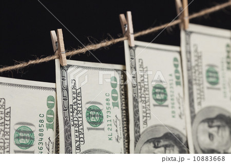 Hundred Dollar Bills Hanging From Clothesline on Dark Background 10883668