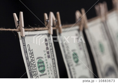 Hundred Dollar Bills Hanging From Clothesline on Dark Background 10883673