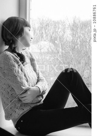 Young woman looking through window 10886761