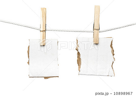two ripped pieces of card board hanging on one clothespins, isol two ripped pieces of card board hanging on one clothespins, isol 10898967