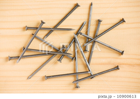 Heap of iron nails on wooden floor 10900613