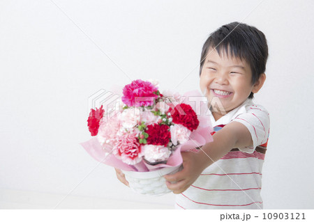 カーネーションの花束を持つ子供の写真素材