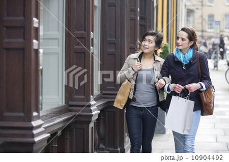 Two happy women shopping together, having fun and laughing 10904492