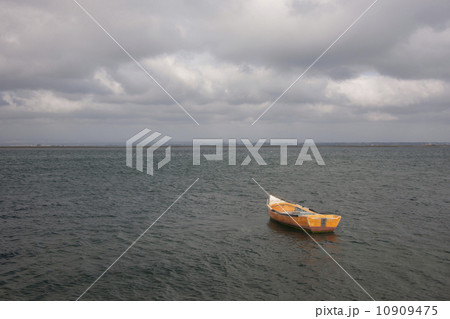 A small wooden boat moored in open water, off the Portuguese coast. A small wooden boat moored in open water, off the Portuguese coast. 10909475