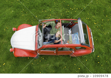 View from above of two people, a couple in a car with the roof open. 10909478