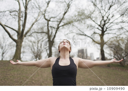 A young woman in Central Park, in a black leotard and leggings, doing yoga. A young woman in Central Park, in a black leotard and leggings, doing yoga. 10909490