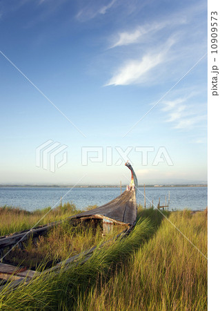 An abandoned wooden moliceiros fishing boat on the dunes overlooking the sea. An abandoned wooden moliceiros fishing boat on the dunes overlooking the sea. 10909573