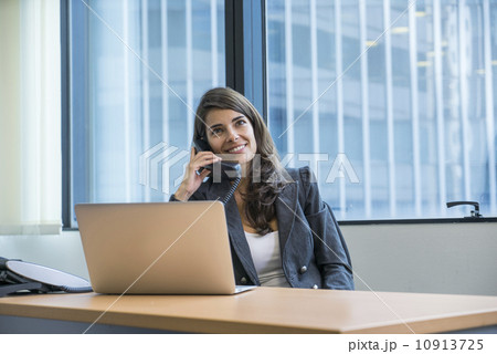 Asian executive in a jacket making a call in the office. Asian executive in a jacket making a call in the office. 10913725
