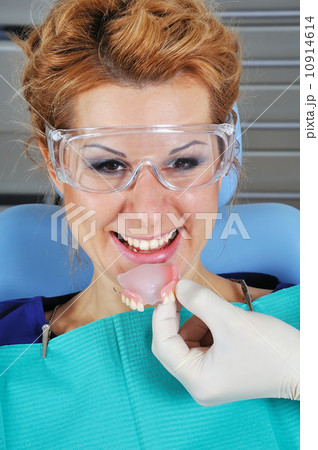 dentist puts denture 10914614