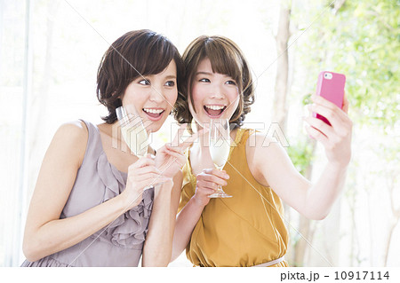 スマホで写真を撮る女性2人の写真素材