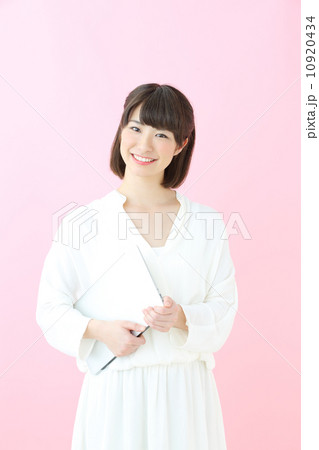 ノートパソコンを持つ若い女の子・ピンクバック ノートパソコンを持つ若い女の子・ピンクバック 10920434