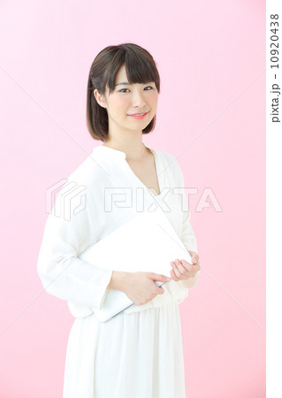 ノートパソコンを持つ若い女の子・ピンクバック ノートパソコンを持つ若い女の子・ピンクバック 10920438