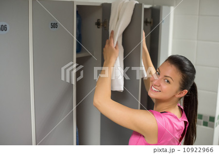 Woman placing towel on locker door Woman placing towel on locker door 10922966