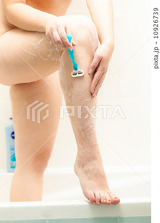 photo of sexy slim woman shaving legs at bathroom 10926739