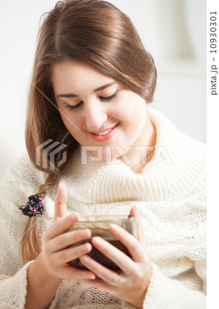 Portrait of brunette woman smiling and holding tea cup 10930301