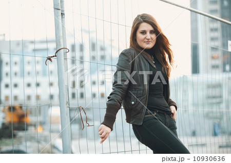 Toned portrait of sexy woman leaning against metal fence 10930636
