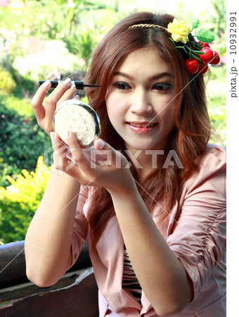 beautiful asian woman applying make up 10932991