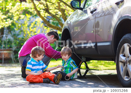 father and two little boys repairing car and changing wheel toge father and two little boys repairing car and changing wheel toge 10935266