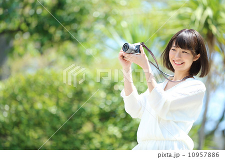 デジカメを持つ若い女性 10957886