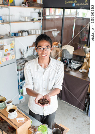 Barista showing coffee beans in his hand. Barista showing coffee beans in his hand. 10960162