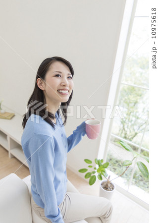 ソファのふちに腰掛ける女性 10975618