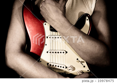 赤いギターを抱く男の写真素材
