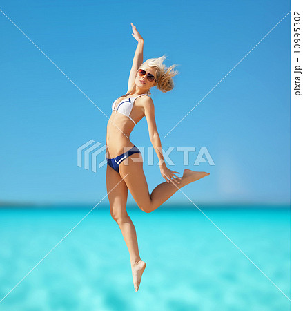 happy woman jumping on the beach happy woman jumping on the beach 10995302