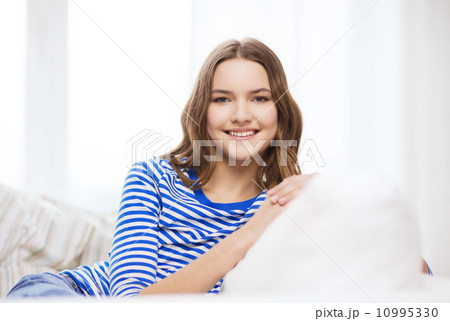 smiling teenage girl sitting on sofa at home smiling teenage girl sitting on sofa at home 10995330