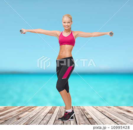 young sporty woman with light dumbbells 10995428