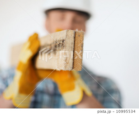 close up of male in gloves carrying wooden boards 10995534