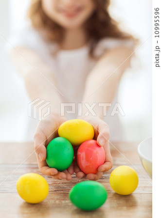 close up of girl holding colored eggs close up of girl holding colored eggs 10995596