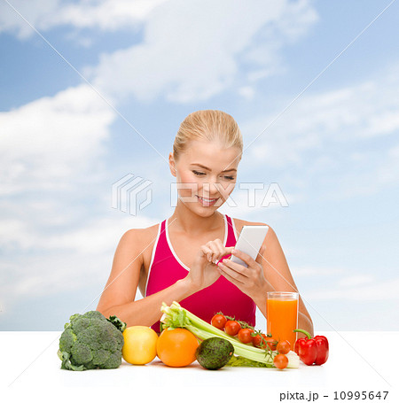 woman with vegetables pointing at smartphone 10995647
