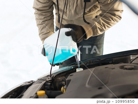 closeup of man pouring antifreeze into water tank closeup of man pouring antifreeze into water tank 10995850