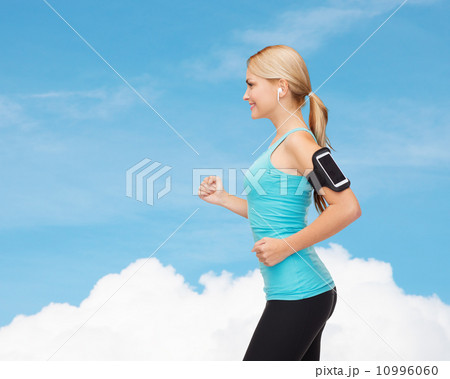 sporty woman running with smartphone and earphones sporty woman running with smartphone and earphones 10996060
