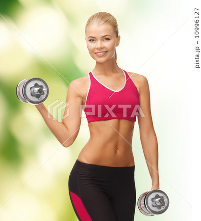 smiling woman with heavy steel dumbbells 10996127