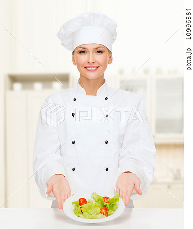 smiling female chef with salad on plate smiling female chef with salad on plate 10996384