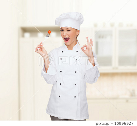 smiling female chef with fork and tomato 10996927