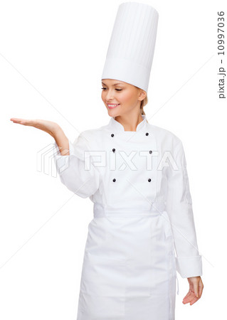 smiling female chef holding something on hand smiling female chef holding something on hand 10997036