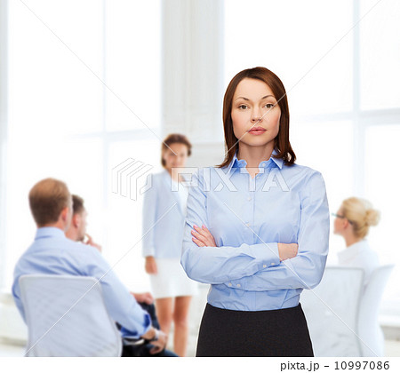 smiling businesswoman with crossed arms at office 10997086