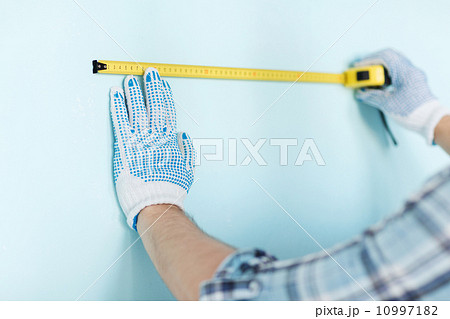 closeup of male in gloves measuring wall with tape closeup of male in gloves measuring wall with tape 10997182