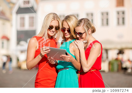 beautiful girls toursits looking into tablet pc 10997274
