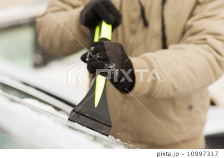 closeup of man scraping ice from car closeup of man scraping ice from car 10997317
