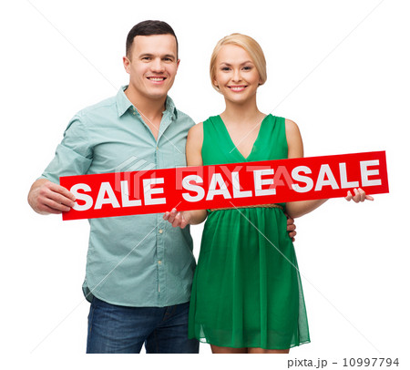 smiling couple with sale sign smiling couple with sale sign 10997794