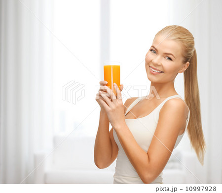 smiling woman holding glass of orange juice smiling woman holding glass of orange juice 10997928
