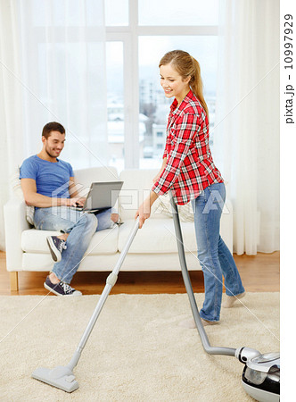 smiling woman with hoover and man with laptop 10997929