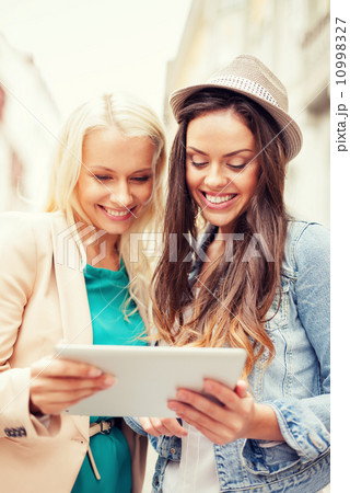 beautiful girls toursits looking into tablet pc beautiful girls toursits looking into tablet pc 10998327