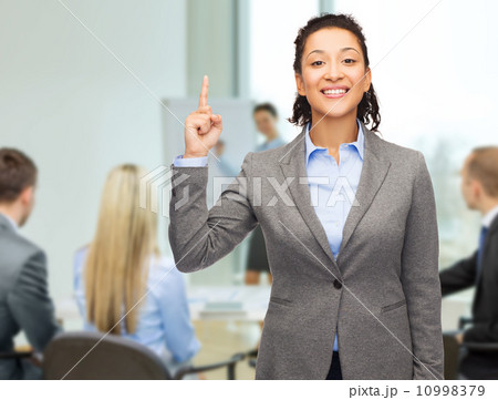 smiling businesswoman with her finger up at office smiling businesswoman with her finger up at office 10998379