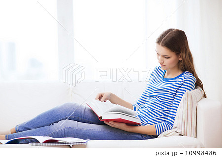calm teenage girl reading book on couch calm teenage girl reading book on couch 10998486