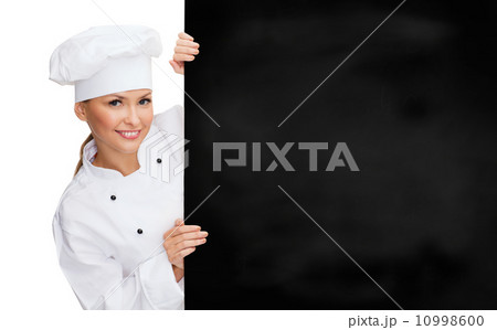 smiling female chef with white blank board 10998600