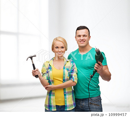 smiling couple with hammer and drill 10999457